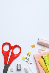 Flat lay composition with different sewing supplies on white background