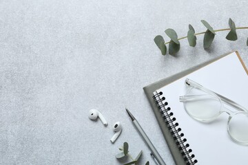 Top view photo of workplace with planner, pen and eucalyptus on gray background with blank space