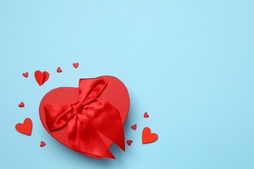 Gift box with red hearts on color background