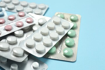 Various blisters with tablets on a colored background