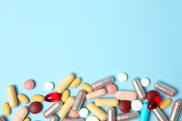 Various tablets and capsules on a colored background