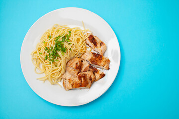 boiled spgaghetti with grilled chicken breast on plate