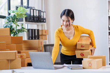 Happy young asian woman SME startup small business freelance work on parcel box and laptop computer , Online marketing packing box delivery SME e-commerce concept