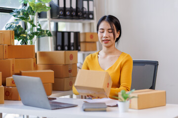 Happy young asian woman SME startup small business freelance work on parcel box and laptop computer , Online marketing packing box delivery SME e-commerce concept