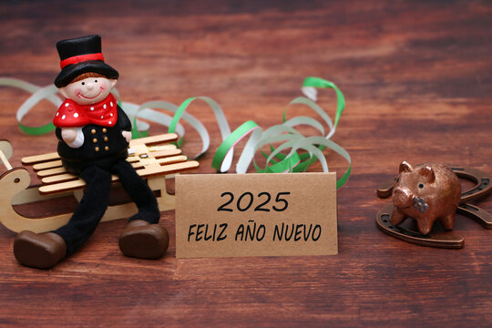 Tarjeta de felicitaci&oacute;n de A&ntilde;o Nuevo: deshollinador, herradura y cerdo de la suerte con serpentinas y felicitaciones por el nuevo a&ntilde;o. Feliz a&ntilde;o nuevo 2025.