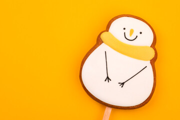Snowman gingerbread cookie on yellow background