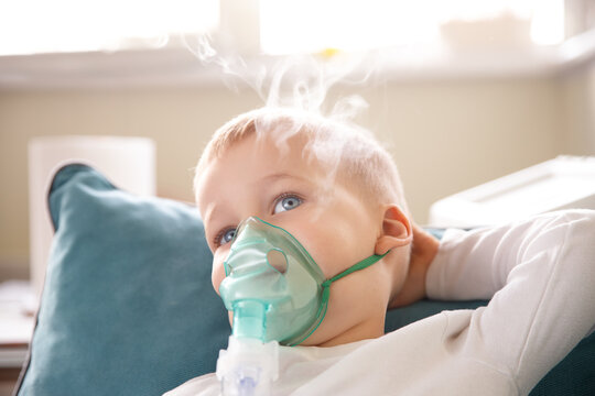 Cute little kid boy wear use medical nebulizer mask inhaling steam respiratory therapy lungs rsv allergic disease cure. Portrait child treating seasonal respiratory bronchitis cough medical inhaler - Powered by Adobe