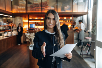 Restaurant owner or manager is standing indoors