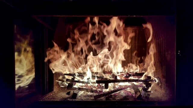 Beautiful shot of camp and fireplace fire burning in the dark at night.