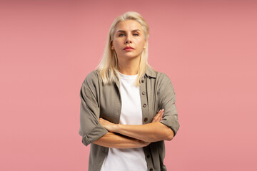 Confident businesswoman crossing arms on pink background