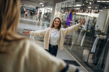 Two women are met at the mall, going to hug, greetings gesture