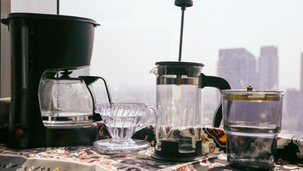 A morning coffee ritual captured in a photo, with coffee brewing tools arranged on a counter overlooking a city view.