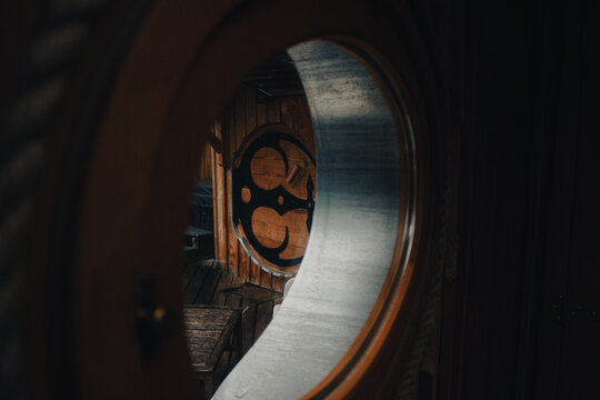 Chalet de Hobbit dans les montagnes, porte ronde au travers d'une fen&ecirc;tre ronde, ferronnerie artisanale et bois.