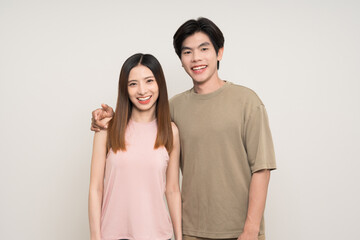 Obraz premium Happy asian couple attractive in various action gesture standing on isolated white background. Cheerful Smiling young man and woman