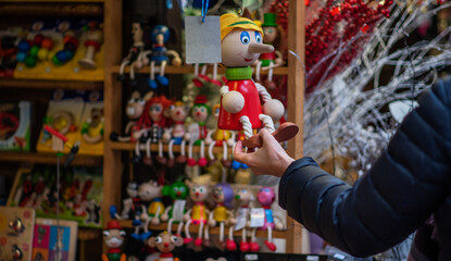 The buyer chooses environmentally friendly plastic-free toys for babies. Wooden toy for a child. Colorful. Crafts. Handmade.