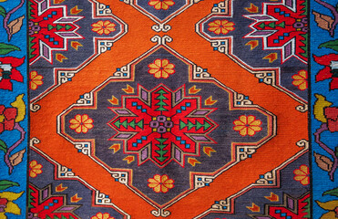 Intricate handwoven rug showcasing a vibrant central medallion in red and green against a deep blue...