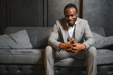 African man in a classic suit on a dark gray background. The concept of classic clothing