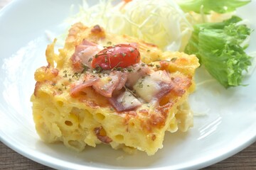 baking macaroni and slice pork bacon with chees topping tomato eat couple salad on plate