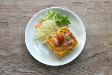 baking macaroni and slice pork bacon with chees topping tomato eat couple salad on plate