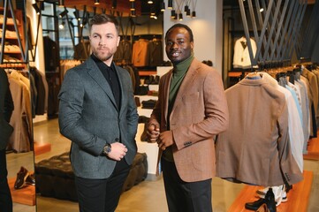 Two handsome respectable men in elegant classic suits in a premium men's clothing store