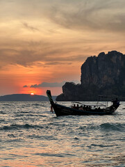 A boat floats serenely on water during a stunning sunset