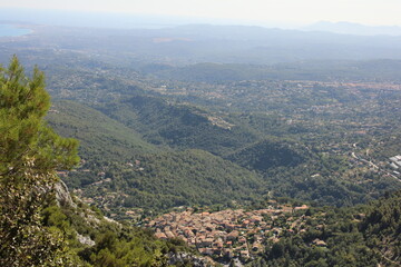 Village de l'arrière Pays Niçois, collines des Alpes en journée, vue pittoresque du Sud de la France avec fond de montagnes