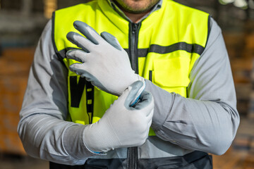 Close up technician engineer wearing and adjust protective safety glove. Safety equipment for...