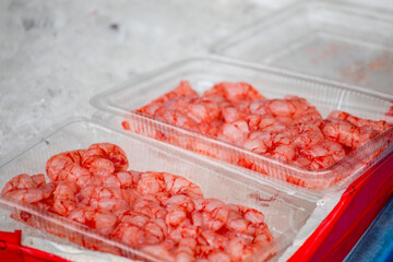 a transparent box is filled with vibrant red shrimp