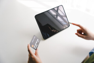 Portrait of person entering credit card information on tablet, shopping online Online credit card payment concept