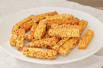 Gozinaki in a ceramic plate. Sweet granola in beige plate for holiday. Vegetarian seed sunflower candies.