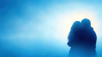 Fototapeta premium Silhouette of Couple Embracing in Blue Misty Atmosphere at Dusk