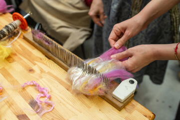Crafting creativity: female hands prepare colorful wool for fiber art creation