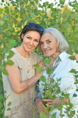 An elderly woman with her daughter in the park in summer
