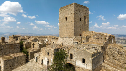 Aerial view of the medieval tower located in Craco, a ghost town in province of Matera, Basilicata, Italy. The historic center was depopulated due to a landslide and has become a tourist destination.