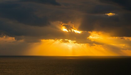 구름이 걷히며 어두운 하늘 사이로 환하게 비치는 황금빛 태양