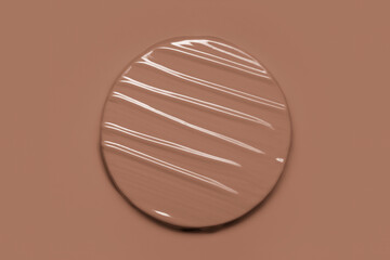 Brown paint, liquid lipstick, foundation cream makeup swatch. Mocha mousse color of the year 2025 background