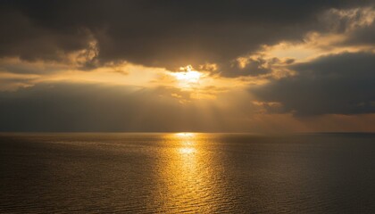 Naklejka premium 구름이 걷히며 어두운 하늘 사이로 환하게 비치는 황금빛 태양