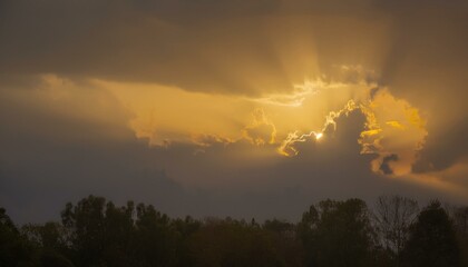 구름이 걷히며 어두운 하늘 사이로 환하게 비치는 황금빛 태양