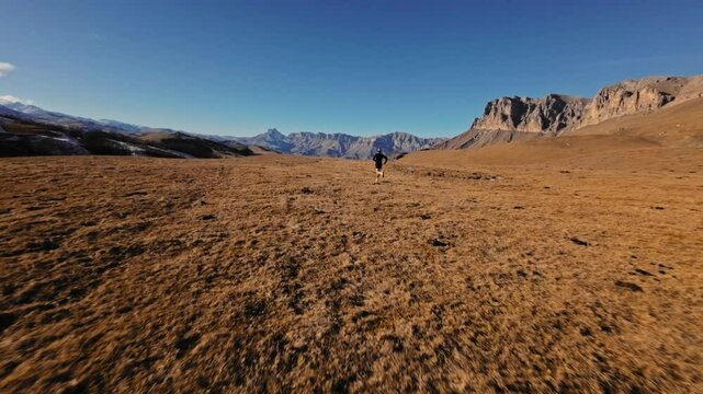 Aerial view man running, freedom, energy, mountain hike trail, FPV drone, happy guy runs trekking route hills valley summit, outdoor in nature, burst of energy
