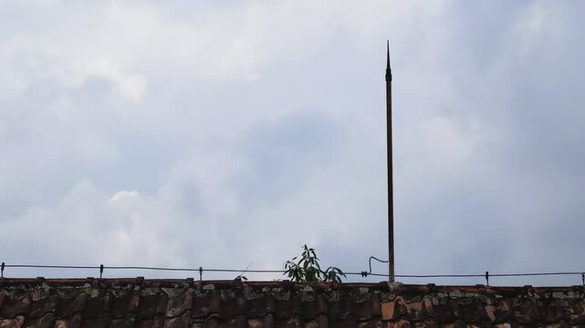 lightning rod, finial, or air terminal is installed on the roof of a building to protect it from lightning strikes