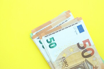 Big amount of one hundred and fifty euro money bills on yellow background