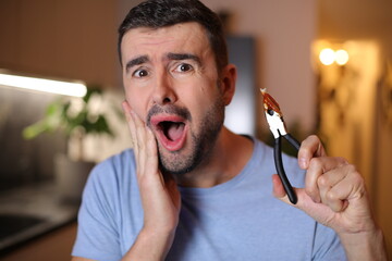 Man removing his own tooth with pliers 