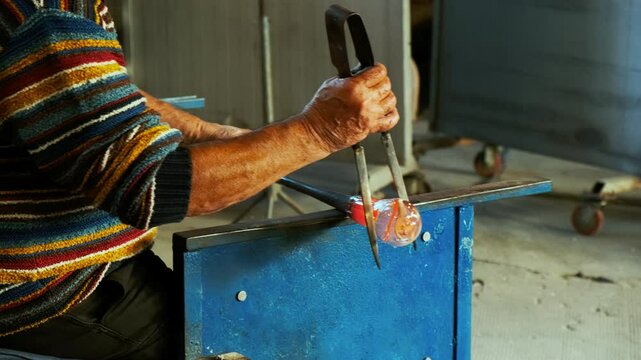 A master glassmaker is seen crafting a beautiful crystal vase out of the finest Murano glass in the island of Murano, Venice, Italy. Venice is an archipelago of 126 islands linked by 472 bridges