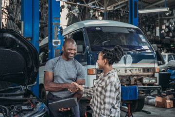 Friendly Handshake Between Mechanic and Customer in Busy Automobile Workshop