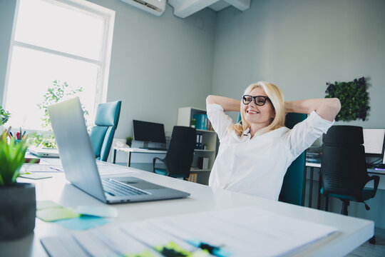 Photo of team leader marketing agency corporation blonde hair woman sitting on workplace take nap comfortable boss chair