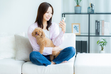 部屋でペットとくつろぐ若い女性