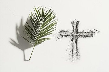 Photo of Ash Wednesday, conceptual still life of a single palm leaf placed next to a cross drawn in ash on a clean white surface 