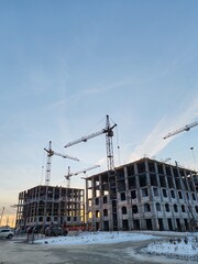 A construction site with cranes and a building in the background
