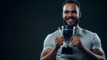 Proud Athlete Holding Championship Trophy with Bright Smile Against Dark Background