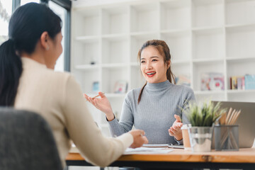 Fototapeta premium Two women having friendly discussion in modern office